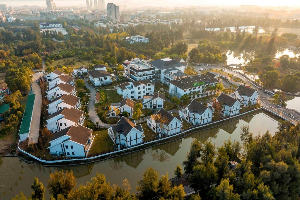 Holiday Inn Express Yuhuan Wetland Park by IHG في Yuhuan: اطلالة جوية على منزل على نهر