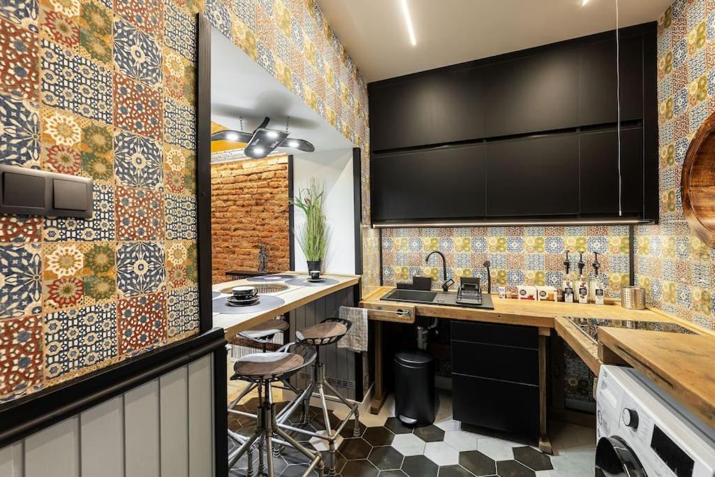 a kitchen with colorful tiles on the wall at Friday’s apartman in Debrecen