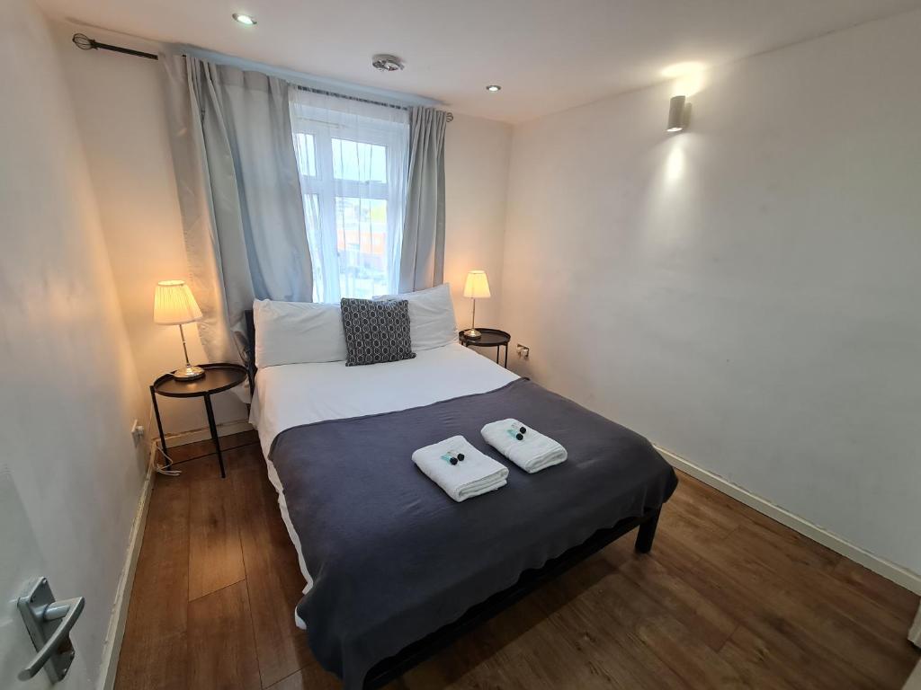- une chambre avec un lit et 2 serviettes dans l'établissement Smart & Bright Apartment, à Londres