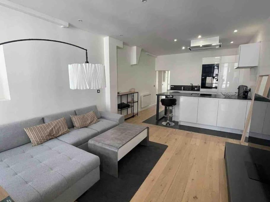 un soggiorno con divano e una cucina di Appartement haut de gamme a Saint-Germain-en-Laye
