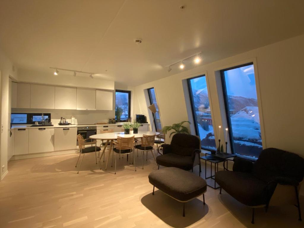a kitchen and living room with a table and chairs at The Heart of Tromsø city Apartment in Tromsø