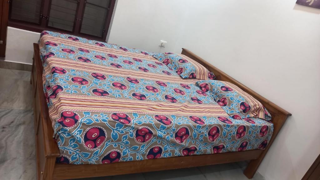 a bed with a blanket on top of it at Niks home stay -C in Trichūr