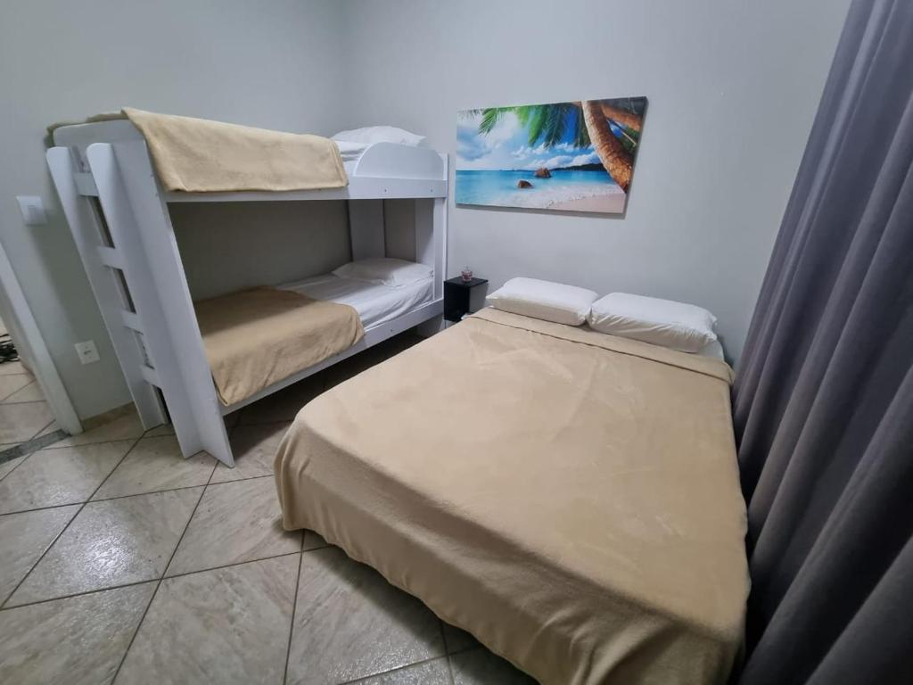 - une chambre avec 2 lits et des lits superposés dans l'établissement Flats Aconchego com Ar condicionado, à Rio das Ostras