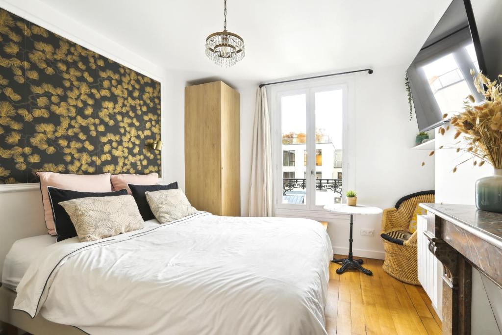 a bedroom with a bed with a floral wall art at PL2 - Stunning architect studio near Le Marais in Paris