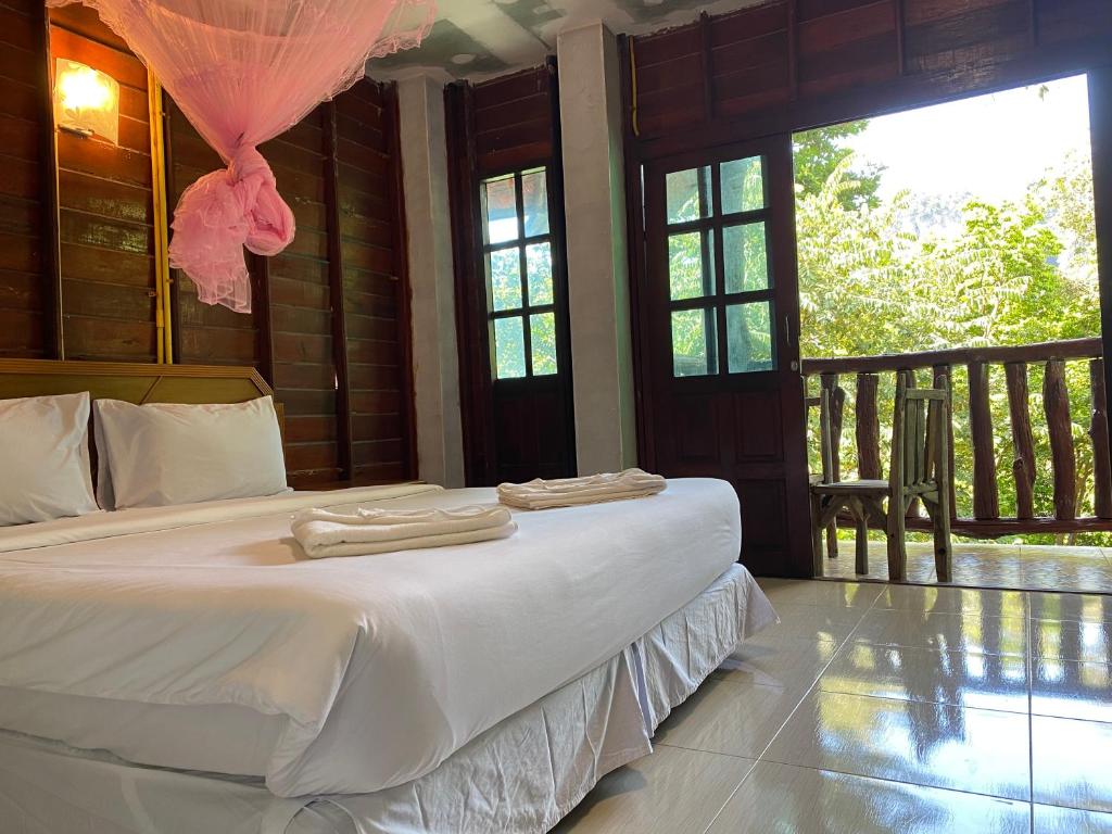 Garden View Resort Tonsai في شاطئ تونساي: غرفة نوم عليها سرير وفوط