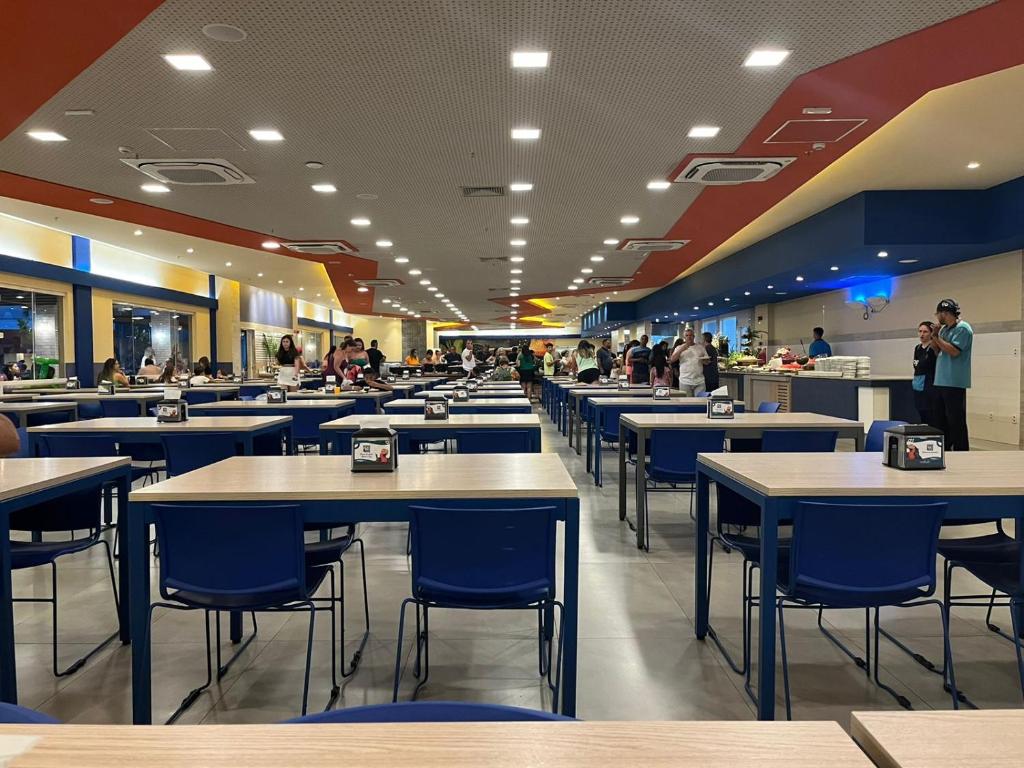un ristorante con tavoli e sedie blu e persone di Solar das Aguas Resort - Olímpia a Olímpia