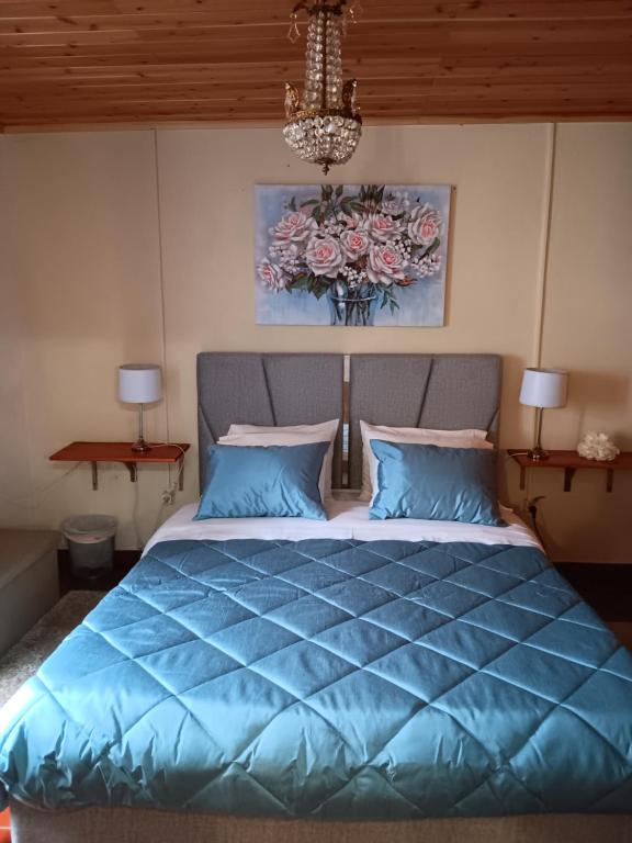 a bedroom with a bed with a blue comforter at Casa do Vale Encantado in Furnas