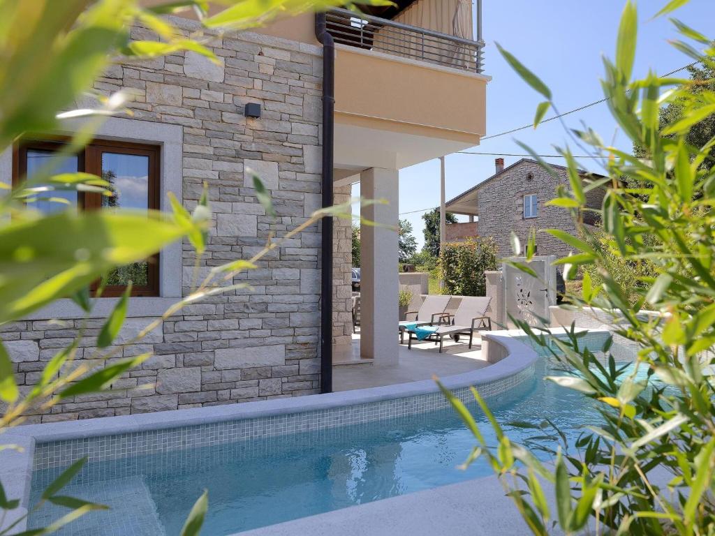 a house with a swimming pool next to a building at Lovely villa with swimming pool and terrace in Hreljići