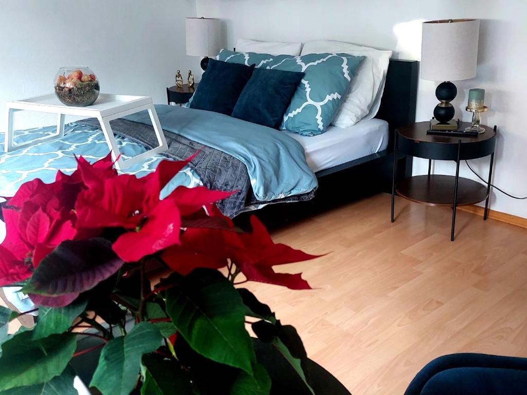 a bedroom with a bed with blue pillows and a plant at Central and calm appartement in Aachen in Aachen