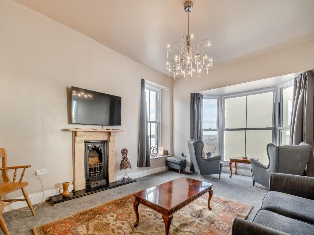 a living room with a couch and a fireplace at Beaufort Apartment in Tenby