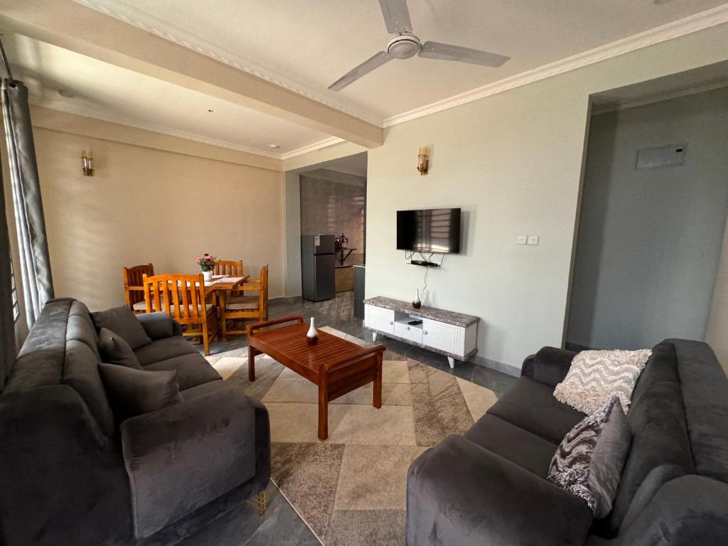 Suji House في دودوما: غرفة معيشة مع أريكة وطاولة