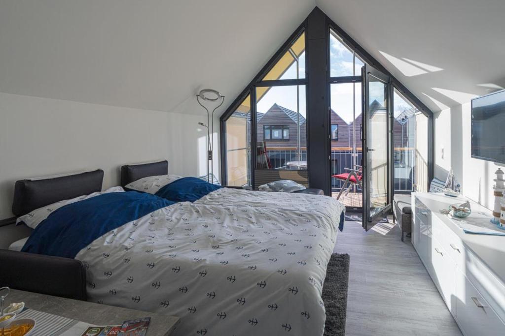 a bedroom with a bed and a large window at Steife Brise in Büsum