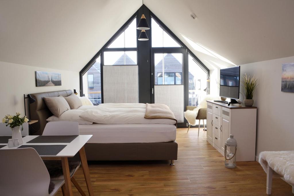 a bedroom with a large bed and a desk in it at Sandbank in Büsum