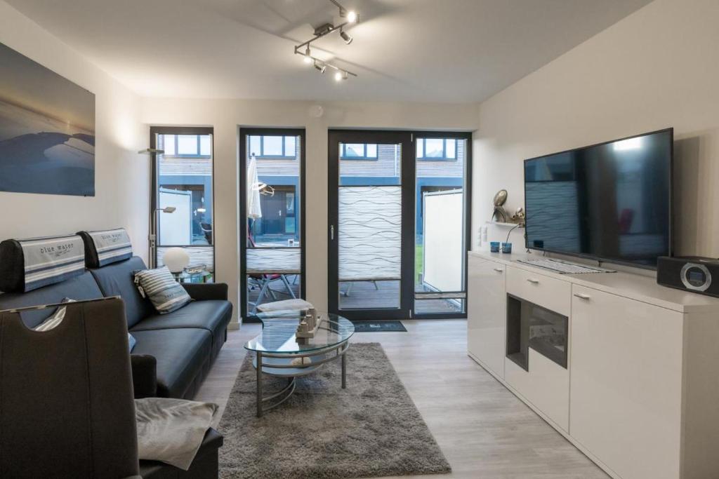 a living room with a couch and a tv at Ankerplatz in Büsum