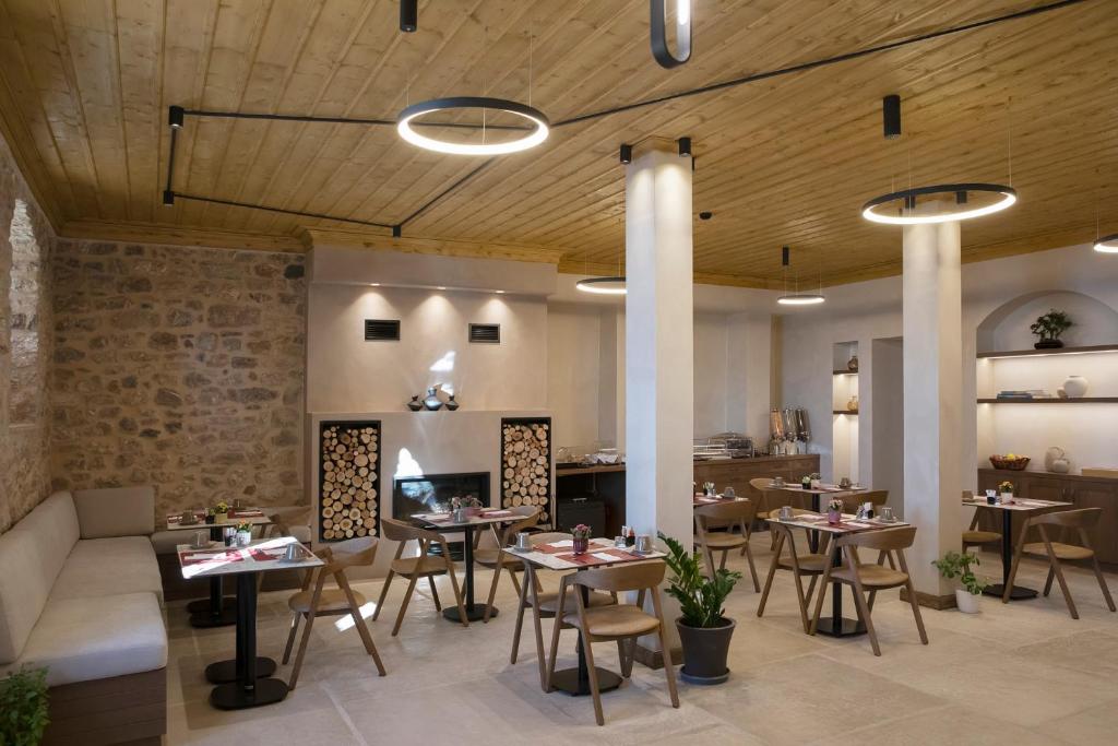 um restaurante com mesas e cadeiras num quarto em Μikri Arktos Boutique Hotel em Dimitsana