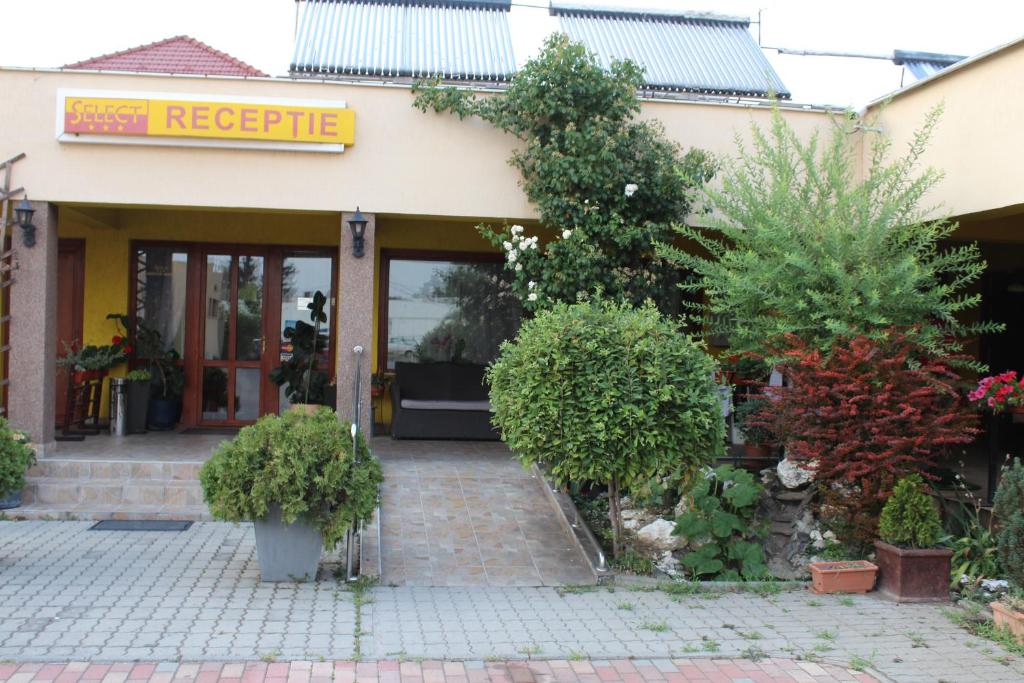 un front de magasin avec des plantes devant lui dans l'établissement Motel Select, à Satu Mare