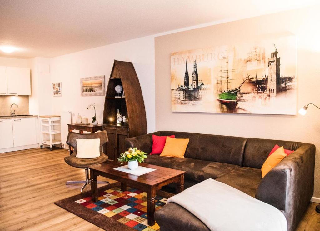 uma sala de estar com um sofá e uma mesa em Appartement Abendsonne em Büsum