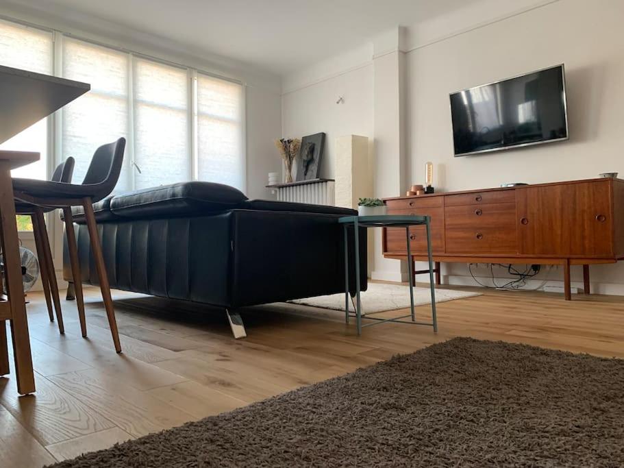 Schlafzimmer mit einem Bett, einem TV und einem Tisch in der Unterkunft Convenience & charm with a view in Maisons-Laffitte