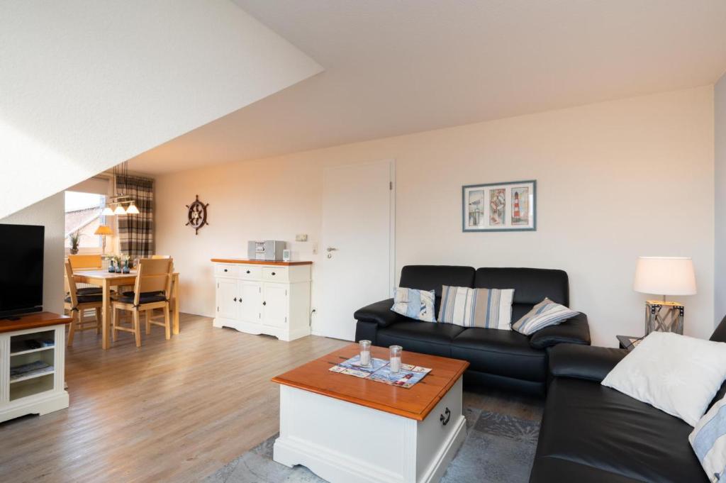 a living room with a black couch and a table at Elbe1 in Büsum