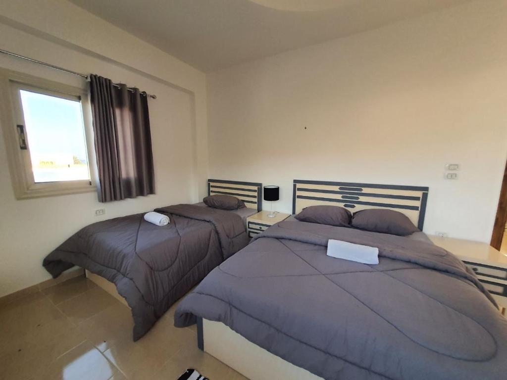 a bedroom with two beds and a window at Al Deira Dahab Residence in Dahab