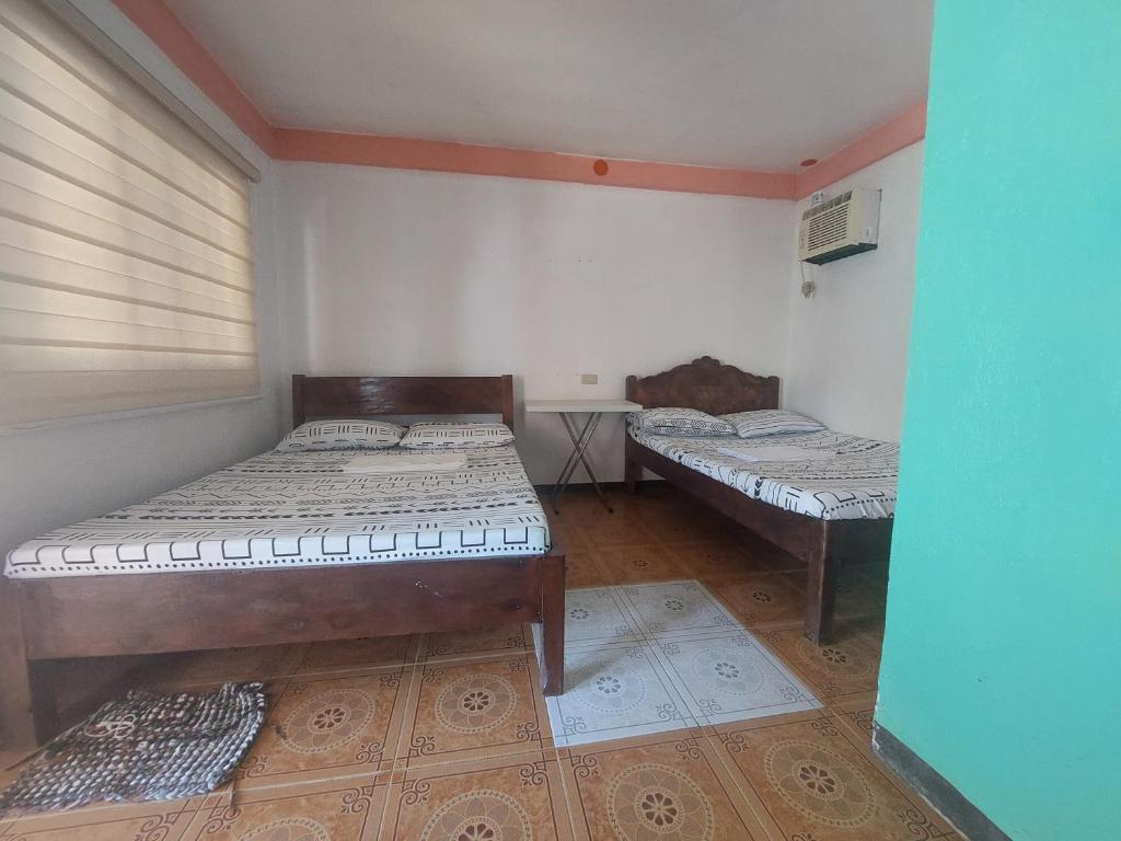 Bolinao的住宿－KNB WEST VILLA INN -PATAR，一间客房内配有两张床的房间