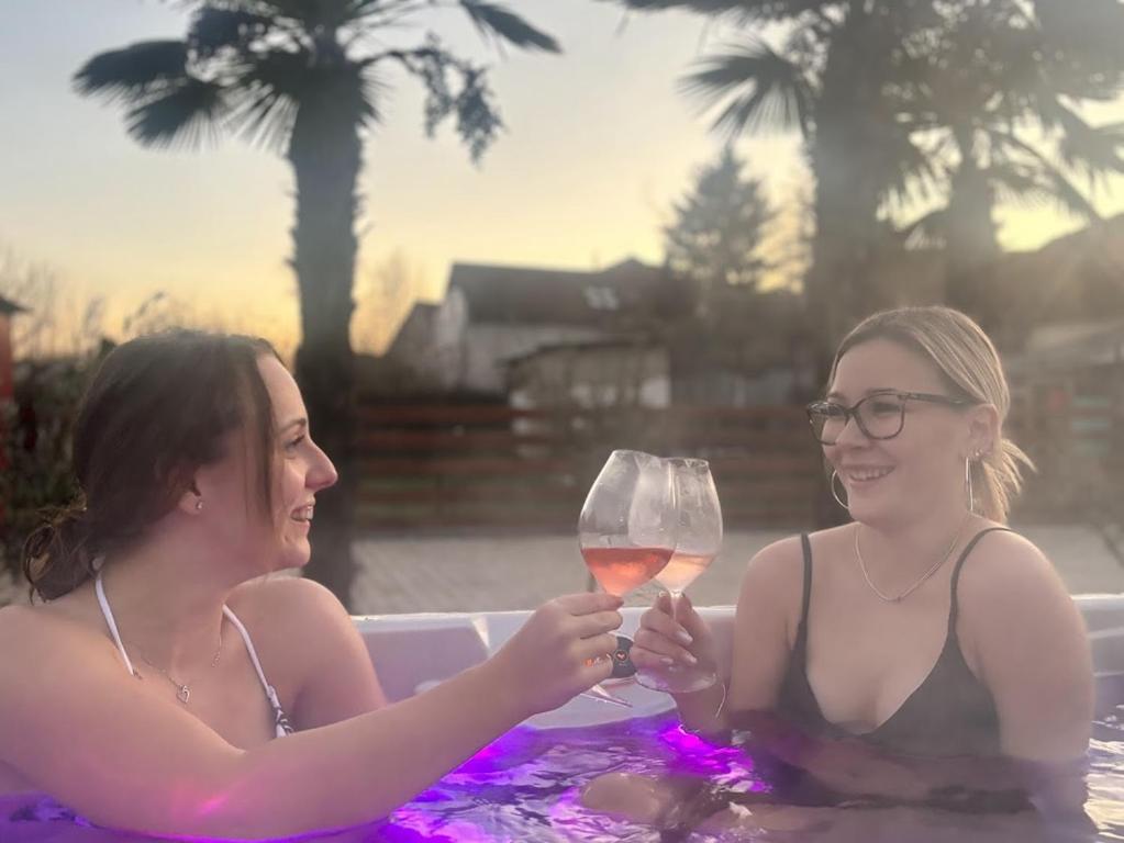 two women sitting in a bath tub with a glass of wine at Rozé Vendégház in Villány