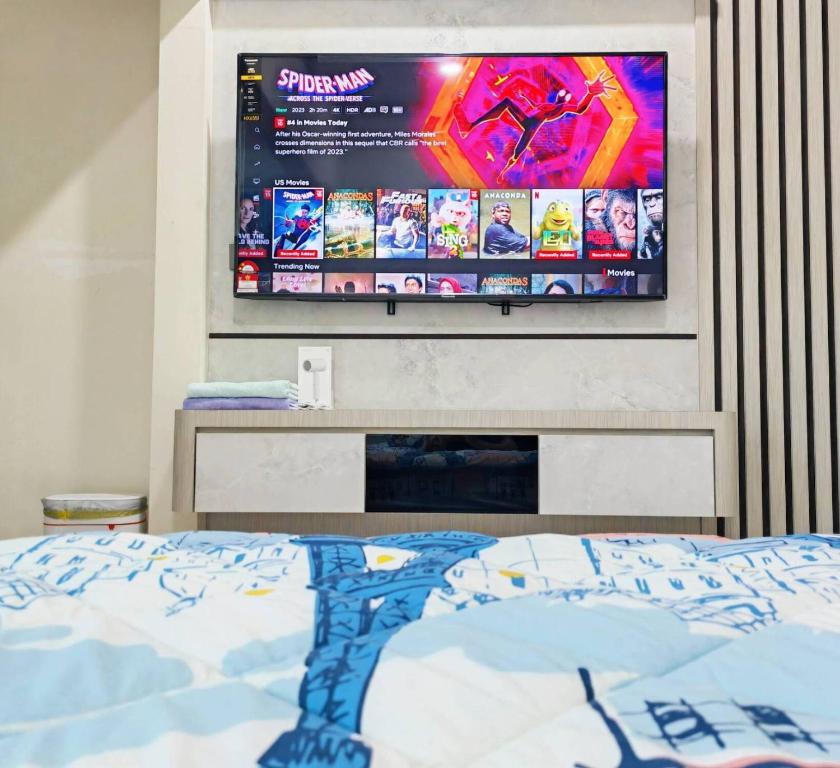 1 dormitorio con TV colgada en la pared en UG Homestay BP - Netflix & 4 Air-Con Rooms, en Batu Pahat