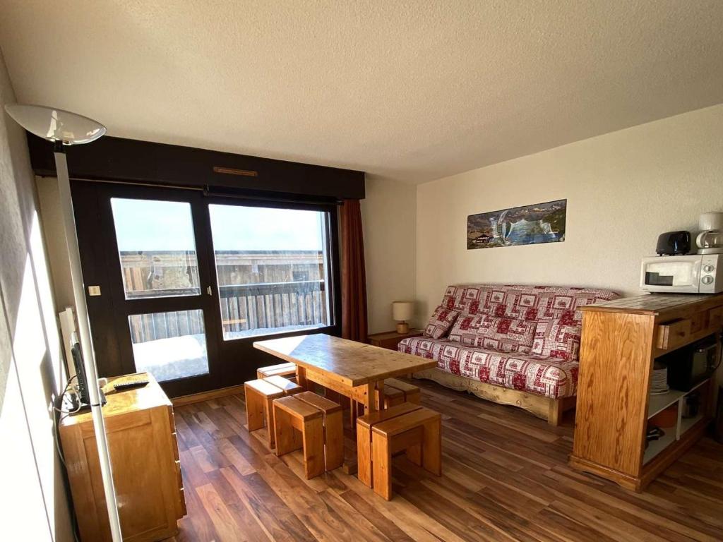 une chambre avec un lit, une table et une fenêtre dans l'établissement Appartement cosy 2 pièces, 6 pers, balcon sud, proche pistes et commerces - Alpe d'Huez - FR-1-405-46, à L'Alpe-d'Huez