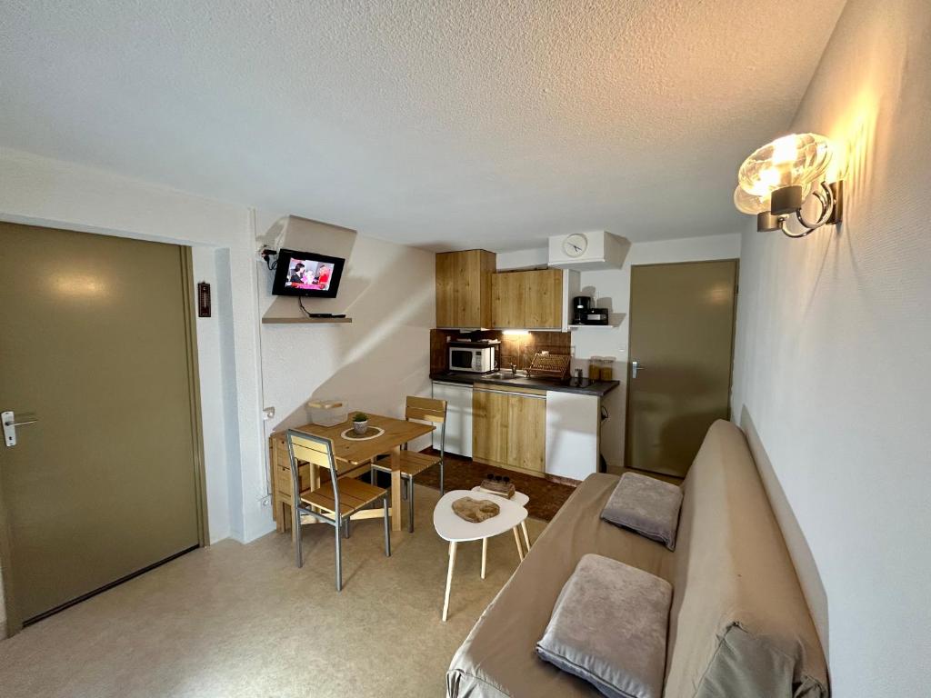 a small living room with a couch and a kitchen at Appartement Saint Lary Soulan Pla d Adet pied des pistes capacité 5pers in Saint-Lary-Soulan