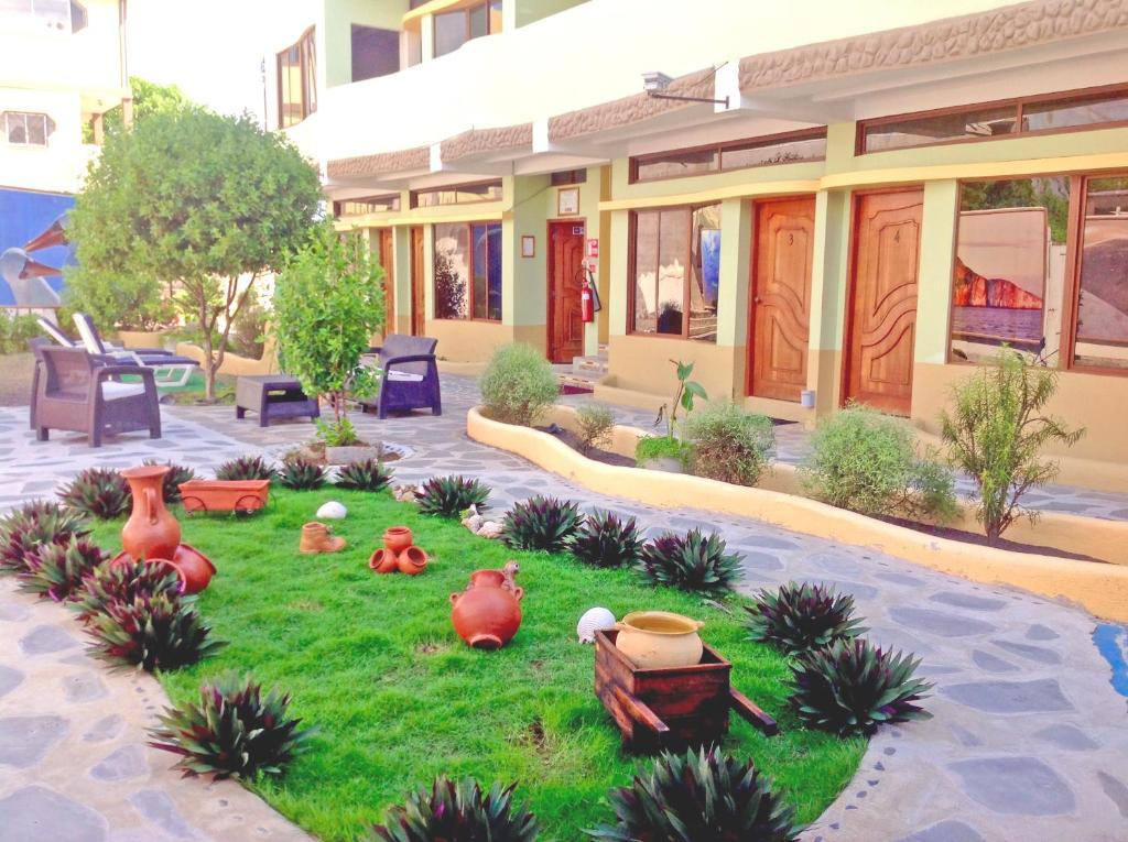 a model of a house with a yard with vases on the grass at Galápagos Eco Friendly in Puerto Baquerizo Moreno