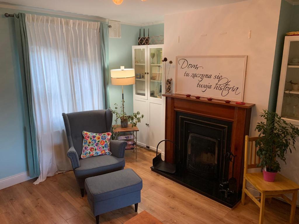 een woonkamer met een stoel en een open haard bij 2 bed Cozy Home Lusk - 15min from Dublin airport! in Lusk