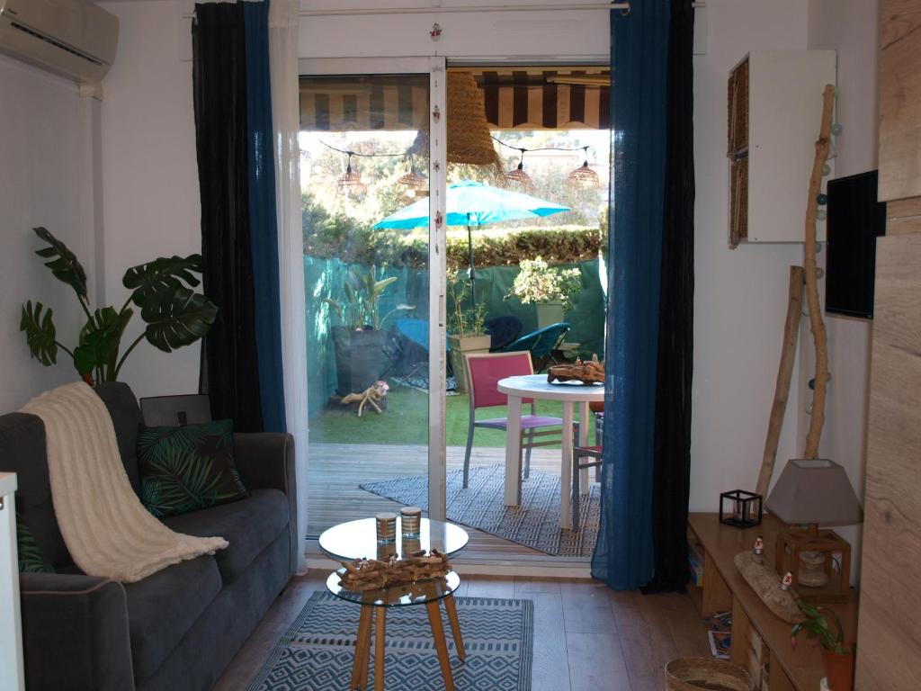 sala de estar con sofá y mesa con sombrilla en Studio le Mistral, en Saint-Raphaël
