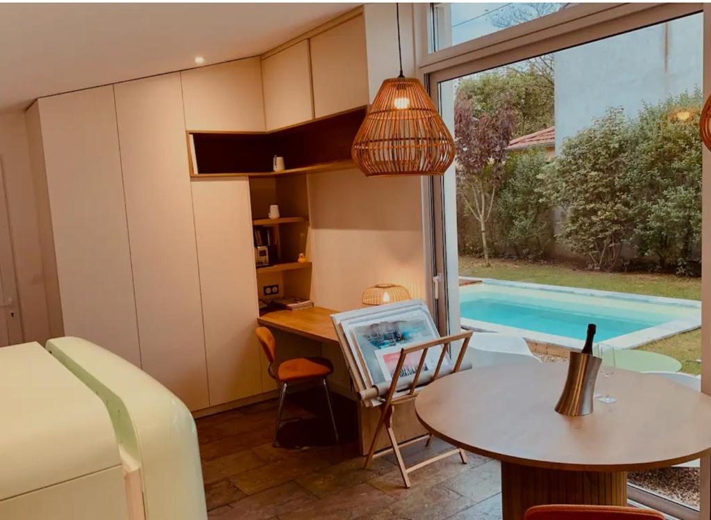 une chambre avec une table et une piscine dans l'établissement Studio Lyon Collonges au Mont d'Or, à Collonges-au-Mont-dʼOr
