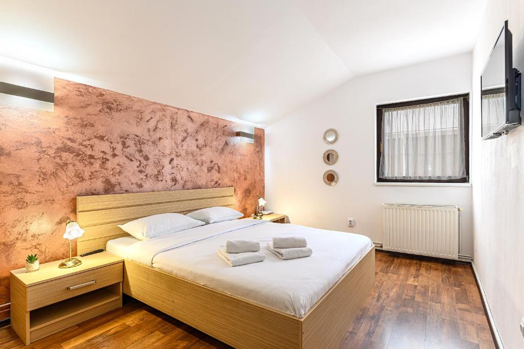 a bedroom with a large bed with white sheets at Elite Neagoe Apartment in Braşov