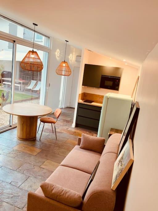 un salon avec un canapé et une table dans l'établissement Studio Lyon Collonges au Mont d'Or, à Collonges-au-Mont-dʼOr