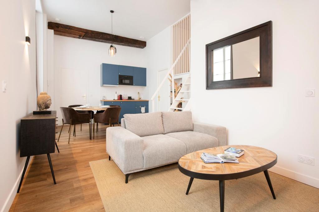 een woonkamer met een bank en een tafel bij Le Laurencin Sens - Le cocon in Sens