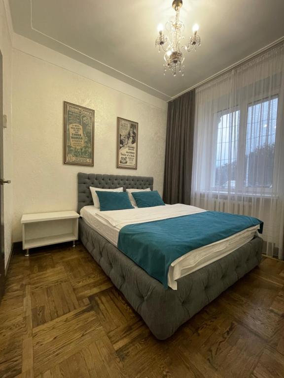 um quarto com uma cama grande e um lustre em Apartment on Soborna 101 em Vinnytsya