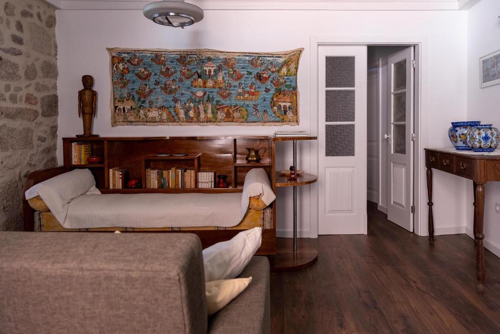 uma sala de estar com um sofá e uma pintura na parede em Casa da Judiaria Velha AP em Viseu