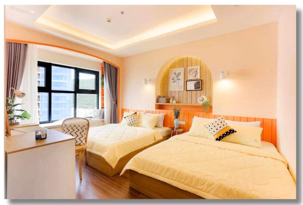 a hotel room with two beds and a window at FLC Luxury Apartment Quy Nhon in Quy Nhon