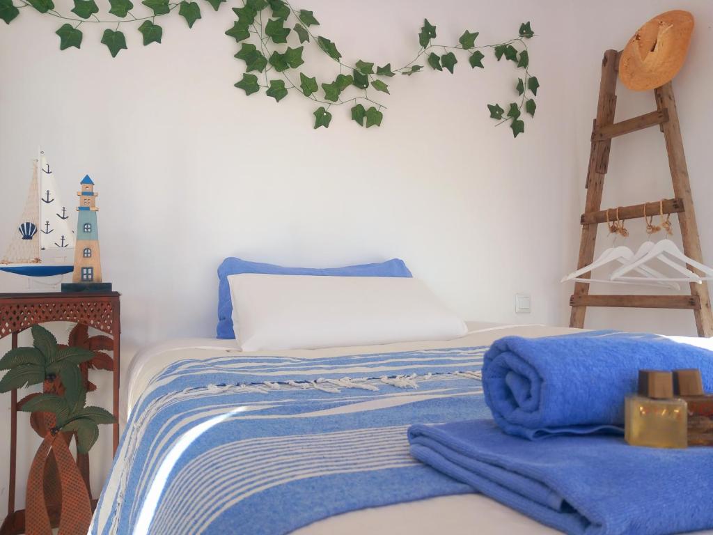 a bedroom with a bed with blue blankets and a ladder at Castell d'Almansa in Cambrils