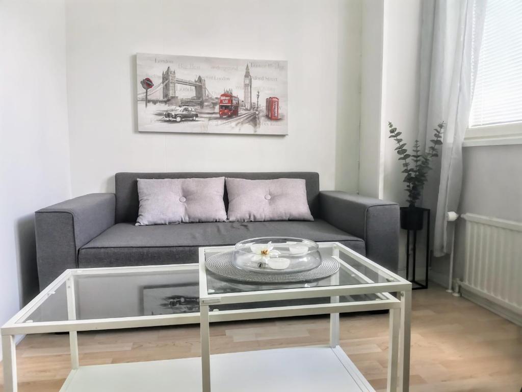 a living room with a couch and a glass table at City Stay Apartments in Jyväskylä