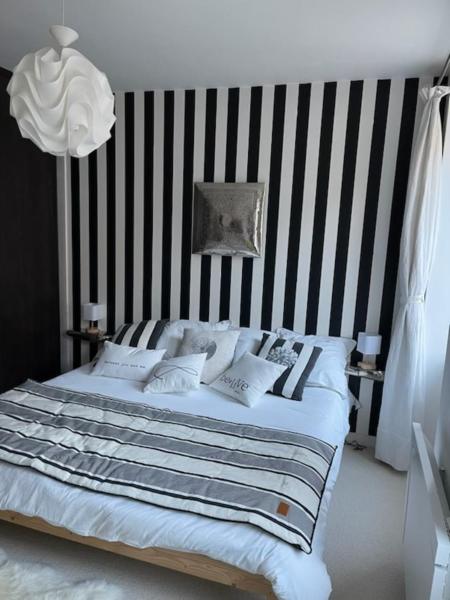 a bedroom with a bed with a striped wall at Chez Céline in Cherbourg en Cotentin