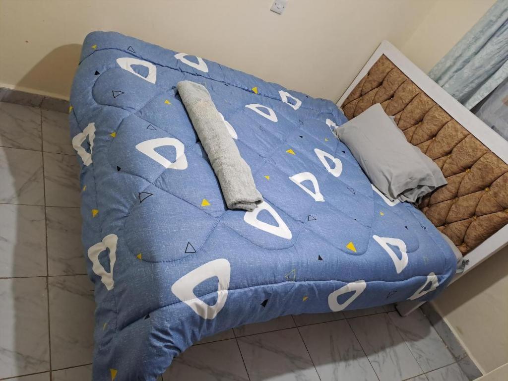 a bed with a blue comforter with white ghosts at Humble homes 1 bedroom Thika Cbd in Thika