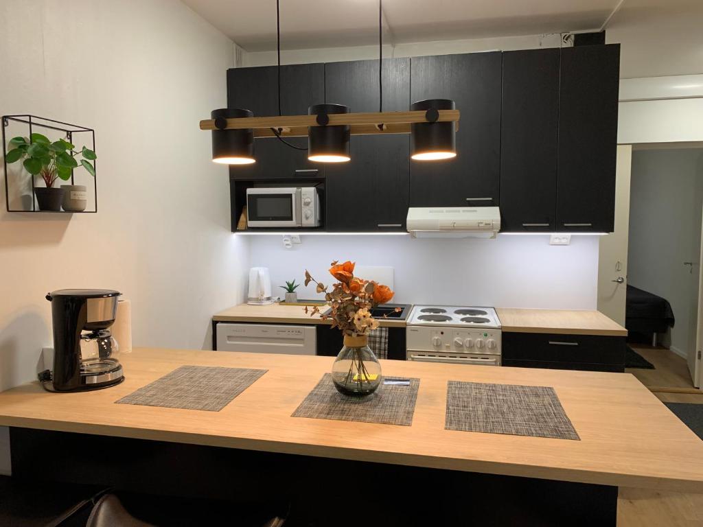 a kitchen with a table with a vase of flowers on it at StarHomes 2 BR City Apartment in Kemi