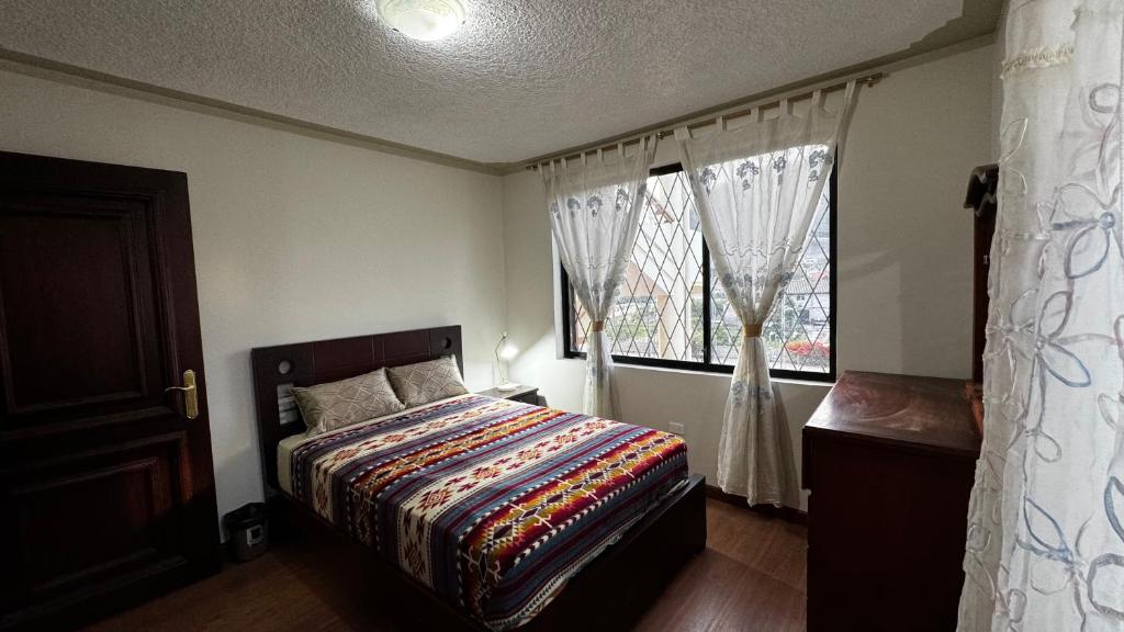 um quarto com uma cama e uma janela em Wasi Golde oro em Otavalo