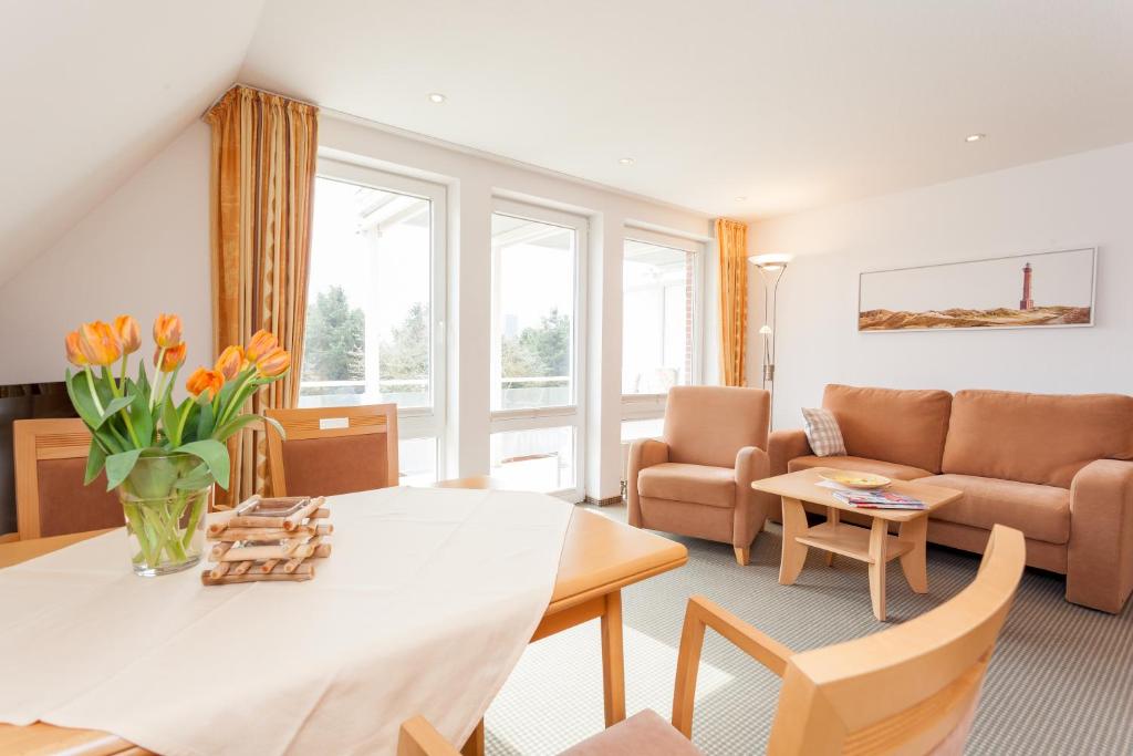 a living room with a table and a couch at Kiefernhaus in Norderney