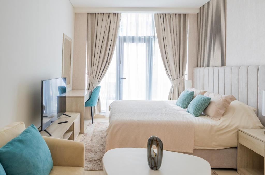 a hotel room with two beds and a television at Studio with pool and private beach access on Palm Jumeirah in Dubai