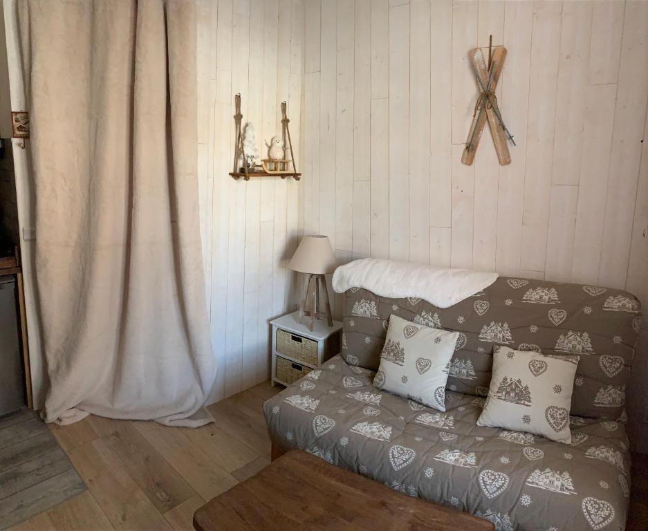 ein Wohnzimmer mit einem Sofa und einem Tisch mit einer Lampe in der Unterkunft Studio 5 couchages SCHUSS 5 la foux d’allos in Allos