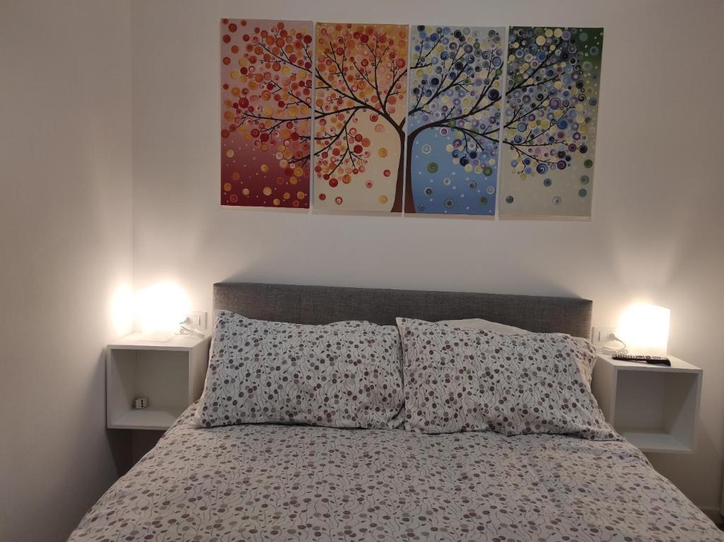 een slaapkamer met een bed en twee schilderijen aan de muur bij KAIROS RESIDENCE in Parma