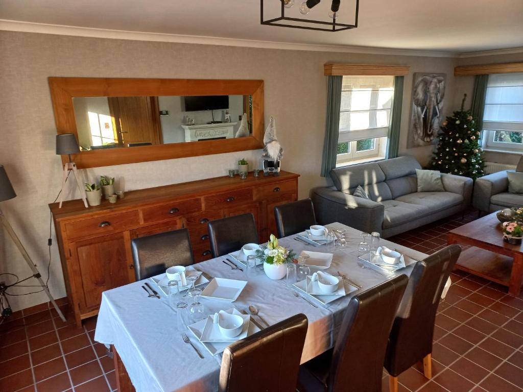a dining room with a table and a living room at Vakantiewoning Steger einde in Oudsbergen 